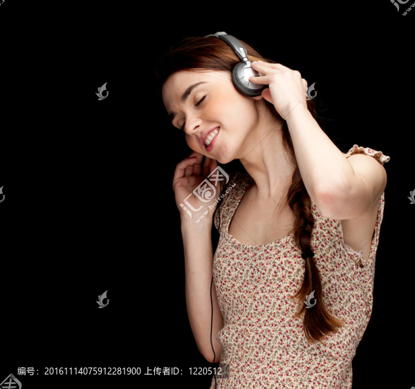 扎馬尾辮的年輕婦女；戴耳機(jī)聽(tīng)音樂(lè)