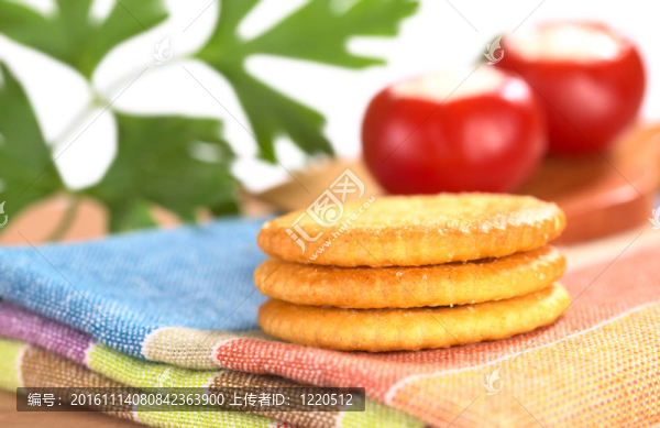 背面有一層圓形的紅胡椒和歐芹葉的一層咸餅干（非常淺的景深；聚焦在餅干前面）