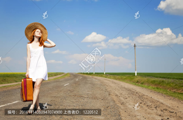 鄉(xiāng)村路上帶著手提箱的寂寞女孩。