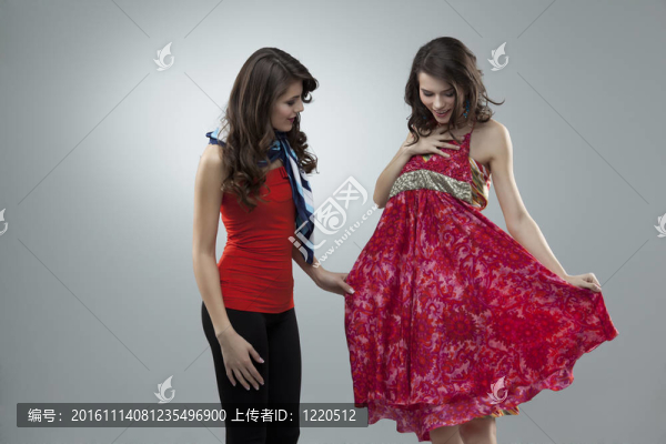 兩個(gè)女人試著穿紅色的花連衣裙