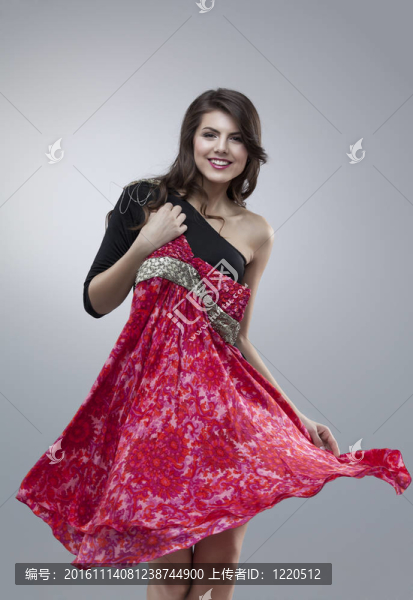 快樂的女人試著穿紅色的花連衣裙