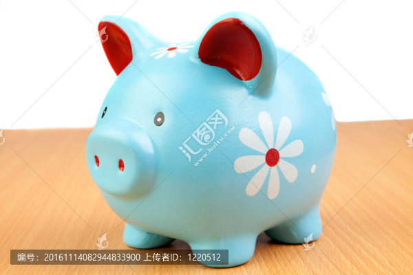 藍(lán)色的小豬銀行在一個木制的桌子上