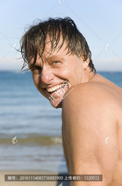 四十多歲的男人微笑的海灘上。