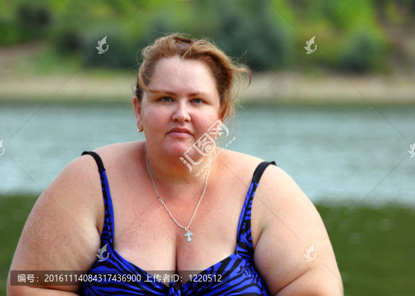 豐滿的女人坐在河邊
