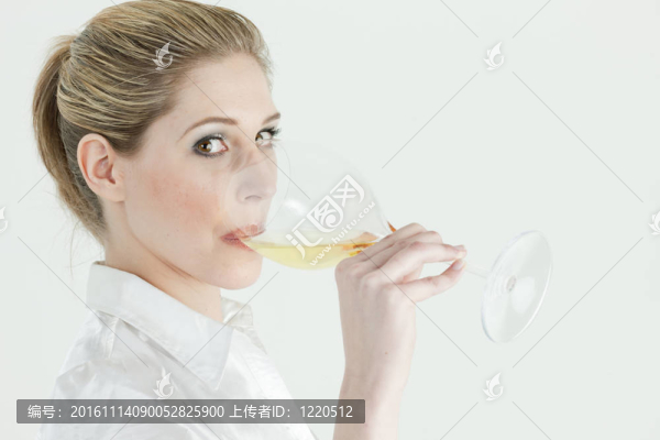 年輕女人喝白葡萄酒的畫像