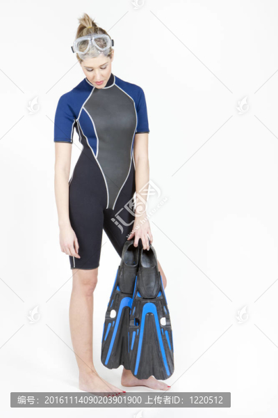 年輕女子站在穿著腳蹼和潛水潛水護(hù)目鏡