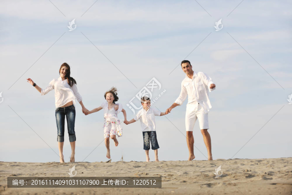 快樂的年輕家庭在海灘上玩得很開心