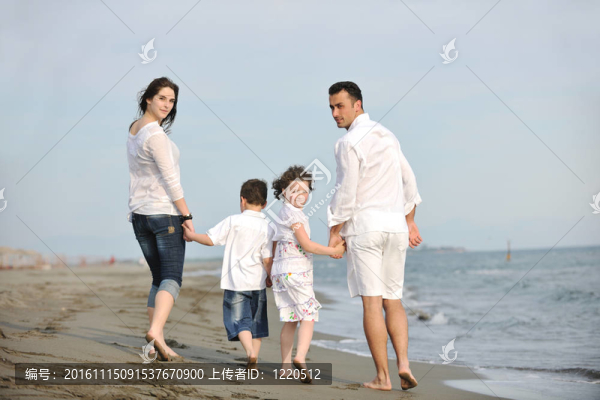 快樂的年輕家庭在海灘上玩得很開心