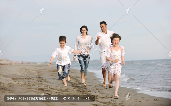 快樂的年輕家庭在海灘上玩得很開心