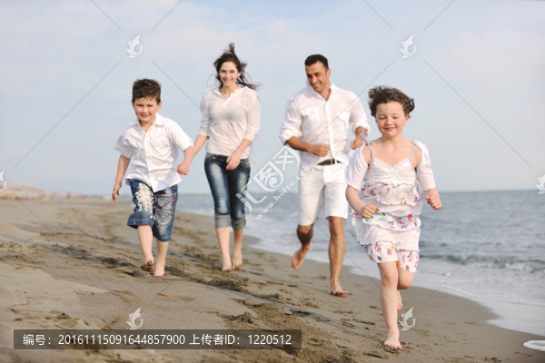 快樂的年輕家庭在海灘上玩得很開心