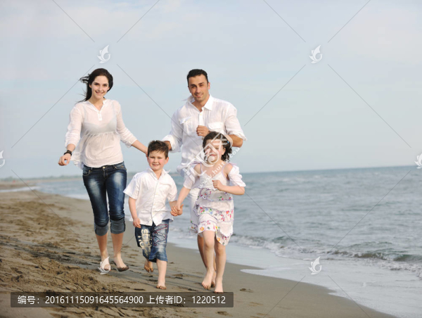 快樂的年輕家庭在海灘上玩得很開心