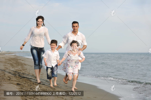 快樂的年輕家庭在海灘上玩得很開心