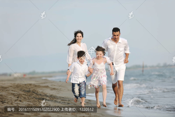 快樂的年輕家庭在海灘上玩得很開心
