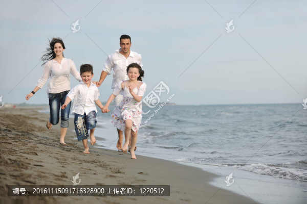 快樂(lè)的年輕家庭在海灘上玩得很開心