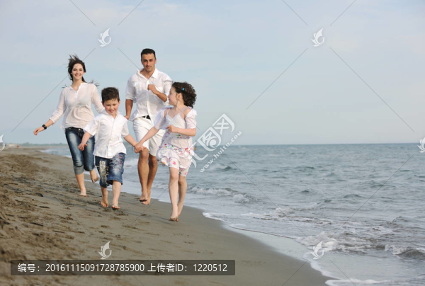 快樂的年輕家庭在海灘上玩得很開心