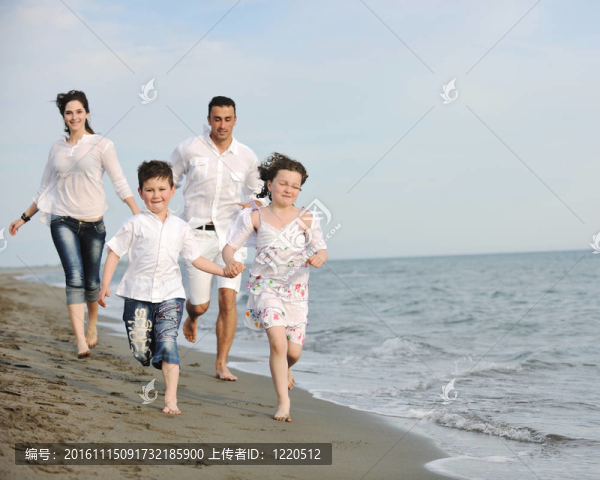 快樂(lè)的年輕家庭在海灘上玩得很開心