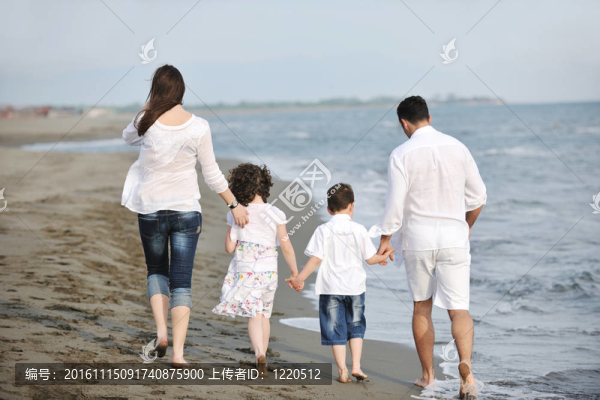 快樂的年輕家庭在海灘上玩得很開心