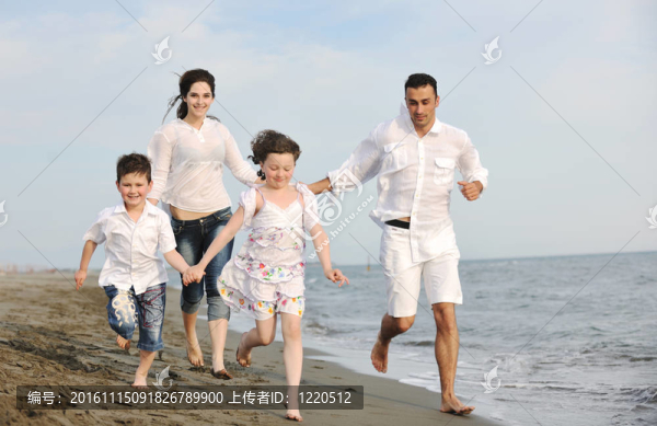 快樂的年輕家庭在海灘上玩得很開心