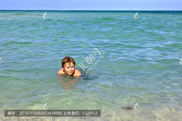 男孩在海洋里享受清澈的水