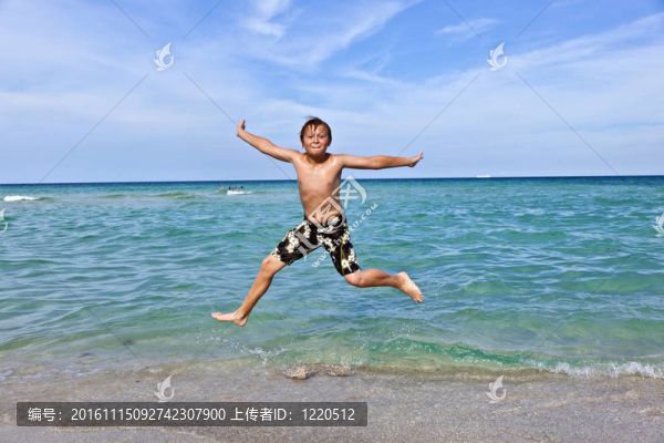 男孩在海洋里享受清澈的水
