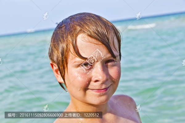 男孩在海洋里享受清澈的水