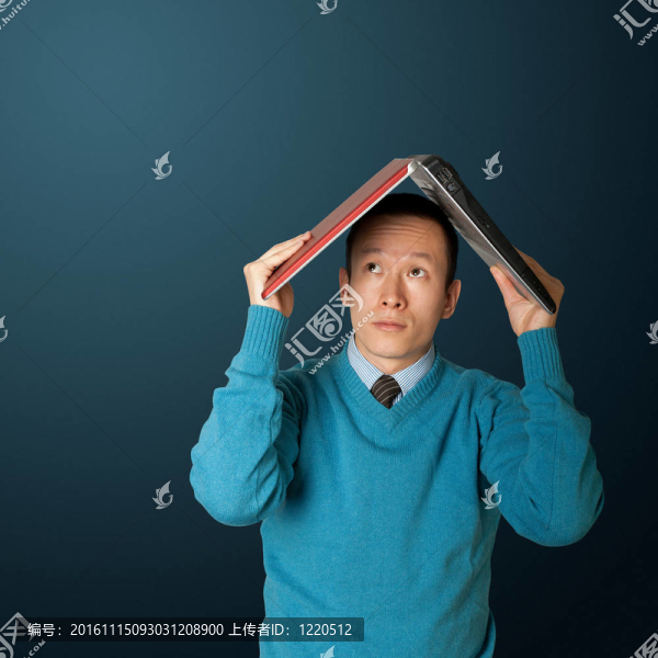 年輕商人藏在筆記本電腦下