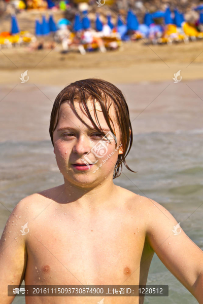 可愛的年輕的快樂的少年在海灘上