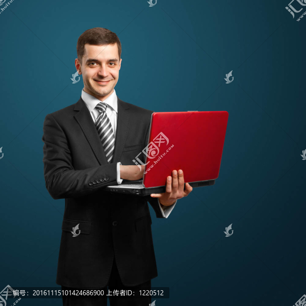 男性在西裝與筆記本電腦在他的手中
