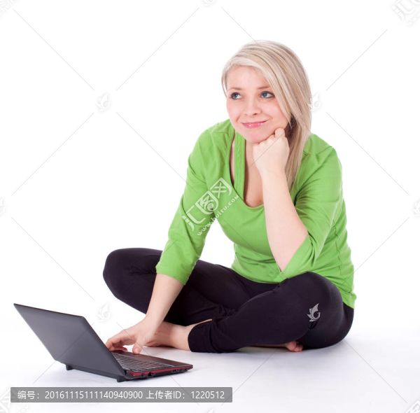 穿綠色休閑襯衫的年輕女性在筆記本電腦上工作