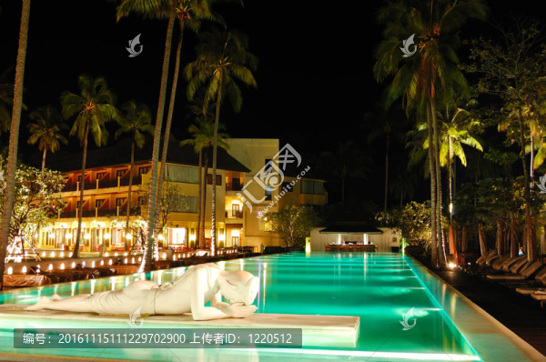 現(xiàn)代游泳池點(diǎn)綴在夜間照明的如來(lái)佛祖雕像；Koh,Chang島；泰國(guó)