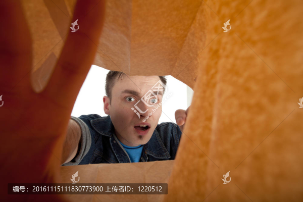 受驚的年輕人看著紙袋