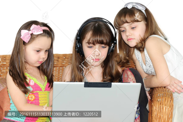 三個小女孩在耳機與筆記本電腦