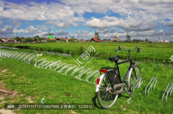 在風(fēng)車的背景下，在綠色的草坪上的自行車。