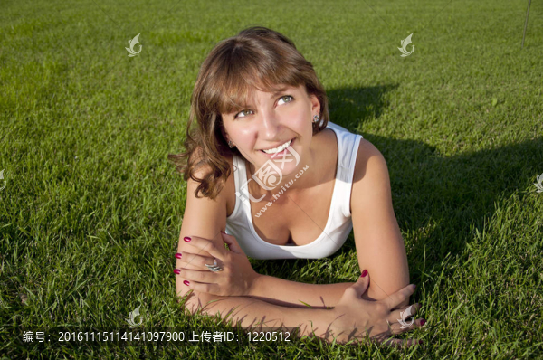 美麗的年輕女子在草地上微笑