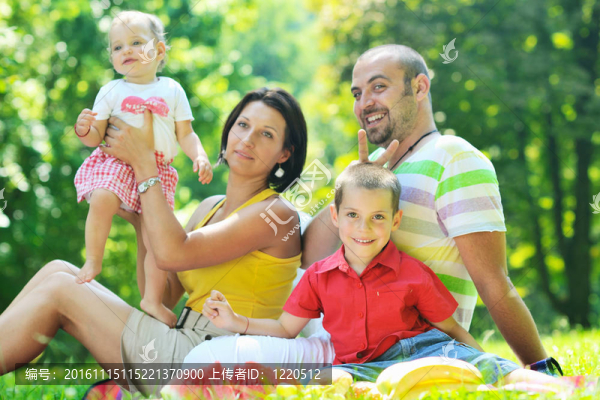 快樂的年輕夫婦和他們的孩子在公園玩得開心