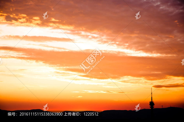 用紅色的云與山的輪廓的城市夜景