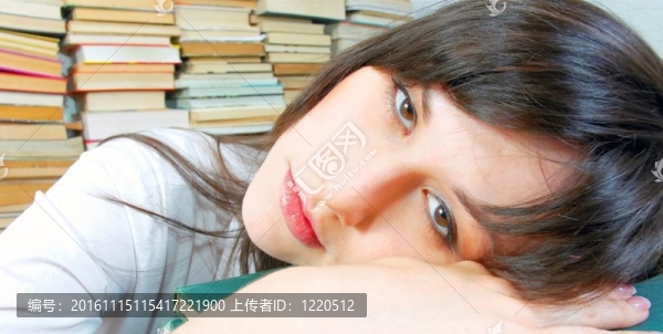 漂亮的年輕學(xué)生女孩幾乎在她的書上睡著了