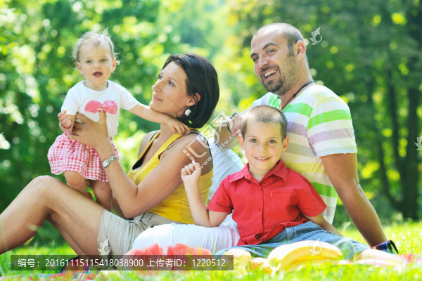 快樂的年輕夫婦和他們的孩子在公園玩得開心