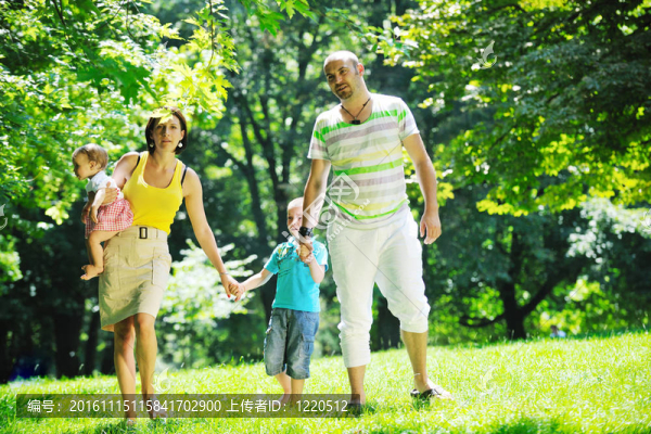快樂的年輕夫婦和他們的孩子在公園玩得開心
