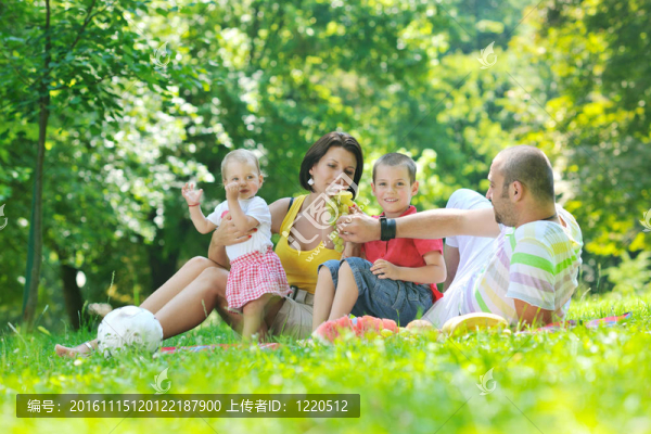 快樂的年輕夫婦和他們的孩子在公園玩得開心