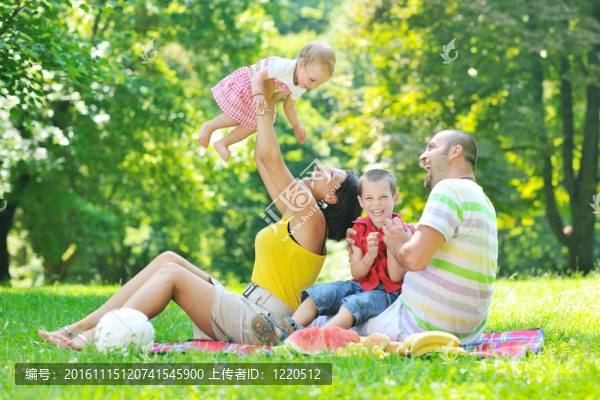 快樂的年輕夫婦和他們的孩子在公園玩得開心