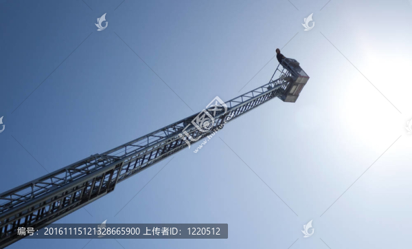 在高高的梯子上的籃子里的男人；在晴朗的藍(lán)天上
