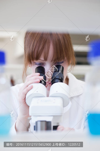 漂亮的女研究員在實驗室用顯微鏡
