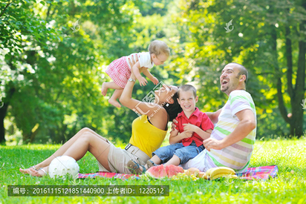 快樂的年輕夫婦和他們的孩子在公園玩得開心