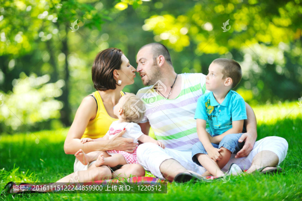 快樂(lè)的年輕夫婦和他們的孩子在公園玩得開心