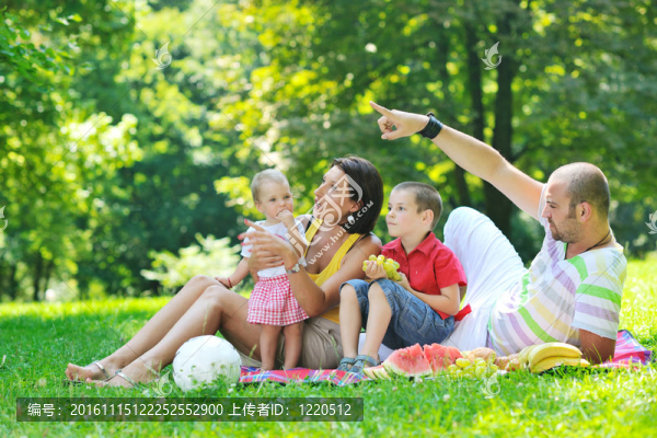 快樂的年輕夫婦和他們的孩子在公園玩得開心