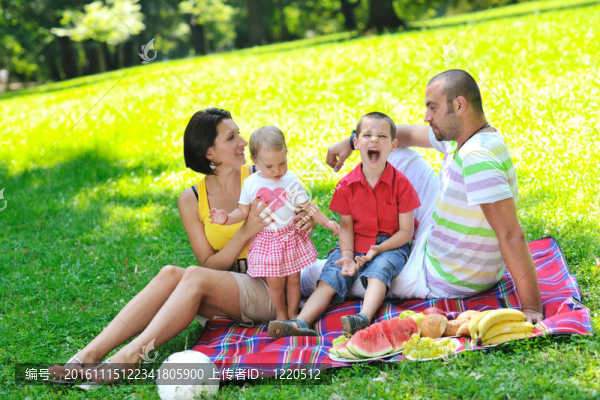 快樂的年輕夫婦和他們的孩子在公園玩得開心