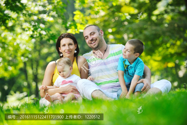 快樂的年輕夫婦和他們的孩子在公園玩得開心
