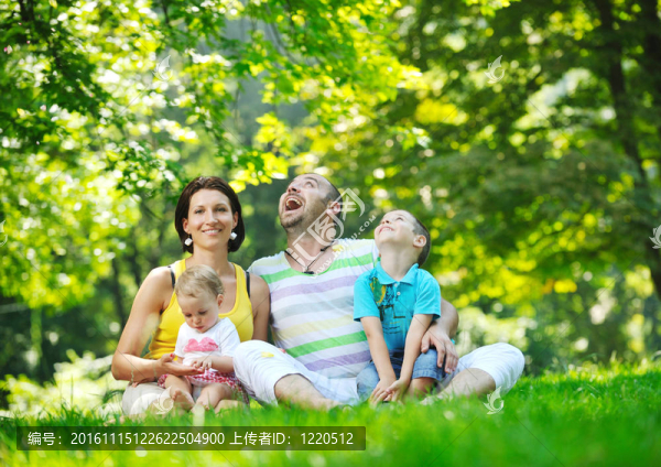 快樂的年輕夫婦和他們的孩子在公園玩得開心