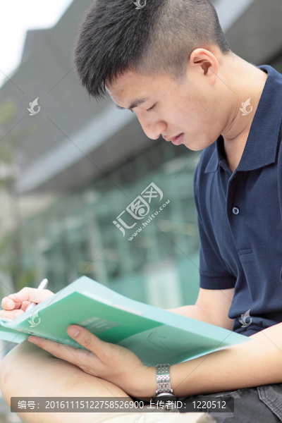 休閑亞洲商人在他的書上發(fā)短信。